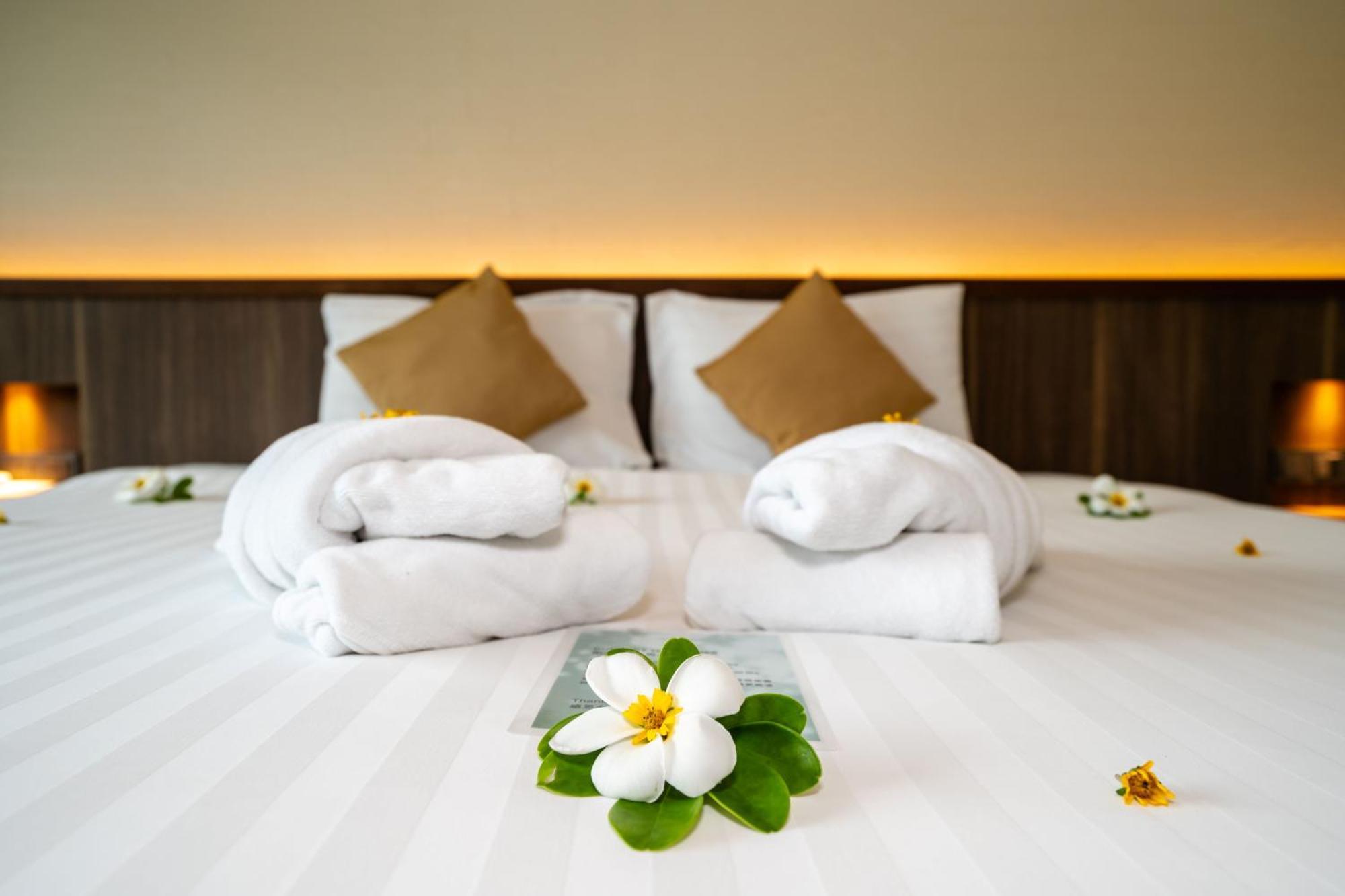 Le Resort And Villas Rawai Kültér fotó A bed with towels and flowers